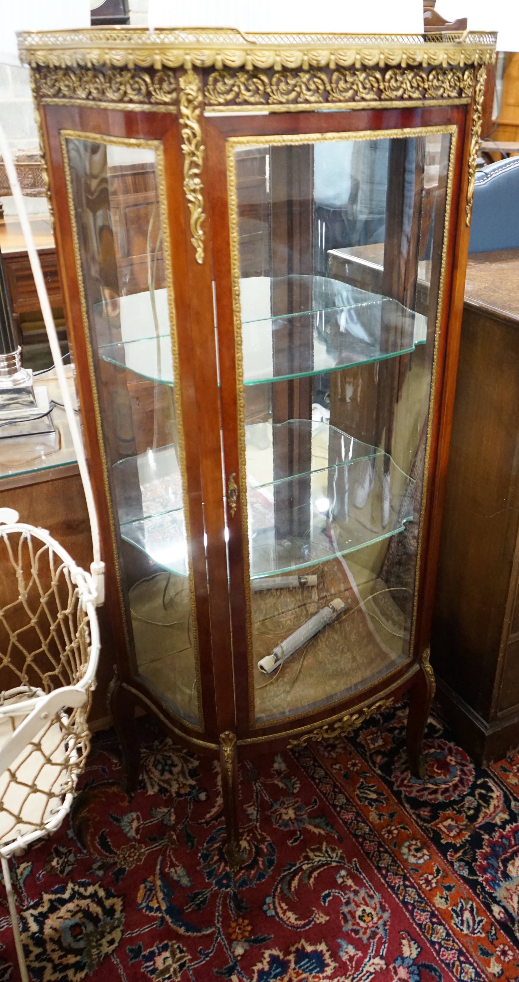 A Louis XV style gilt metal mounted marble topped bow fronted vitrine, width 67cm, depth 34cm, height 139cm